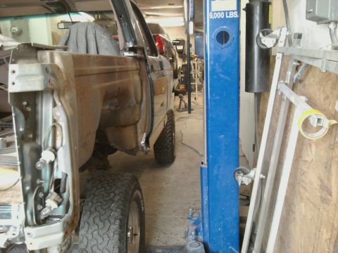 1994 Ford Bronco - The rear quarter panel of a Ford Bronco is exposed, showing rust and damage during a repair process.