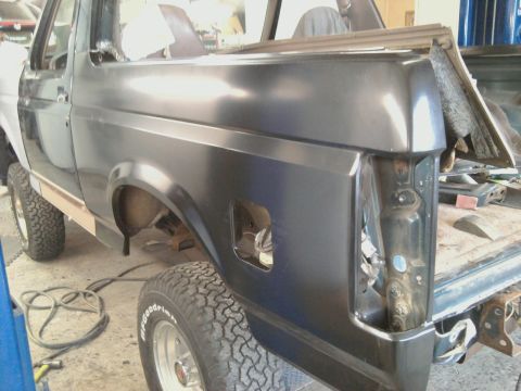 1994 Ford Bronco - This Ford Bronco is in a workshop, with its rear quarter panel exposed and missing its taillight.