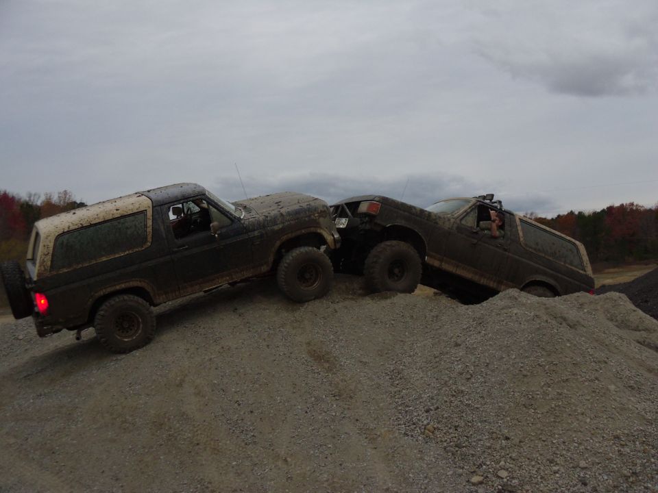Two 1985 Ford Broncos climbing a gravel hill