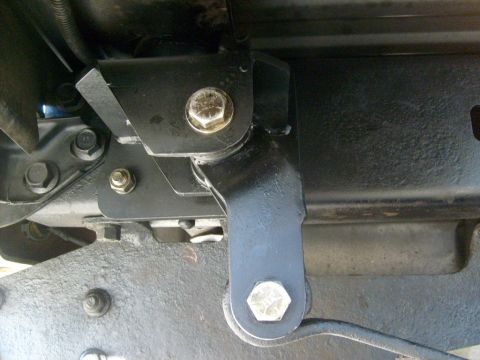 1986 Ford Bronco - Underside view of a vehicle's suspension component, showing a bracket and bolt connection.