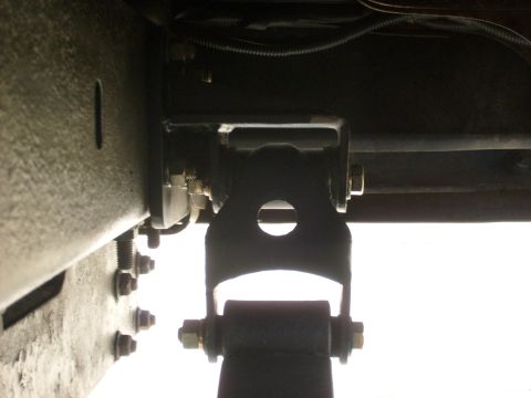1986 Ford Bronco - Underside view of a vehicle's frame and suspension system, showing a bracket and shock absorber attachment.