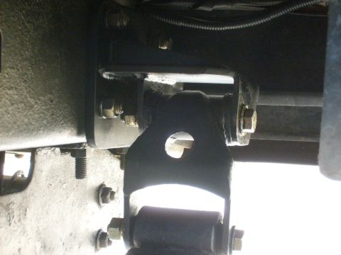 1986 Ford Bronco - A close-up view of a vehicle's suspension system, showing metal brackets and bolts.