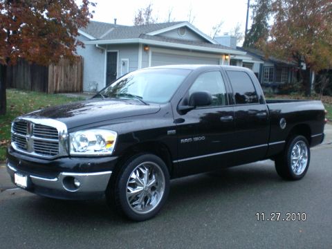 1996 Ford Bronco - A black Dodge Ram 1500 pickup truck is parked on a street in front of a house.