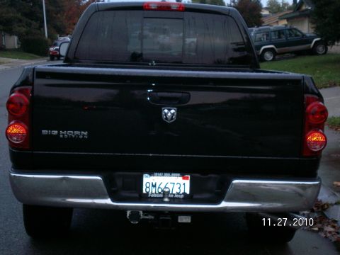 1996 Ford Bronco - Rear view of a black Dodge Ram pickup truck, with a second SUV visible in the background.