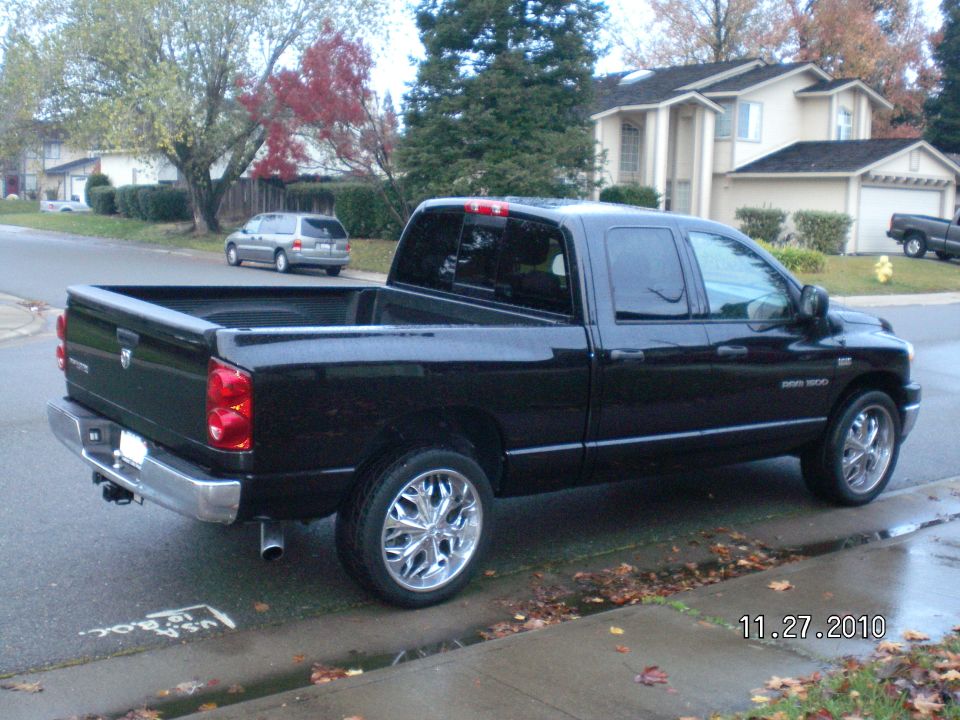 Black Dodge Ram pickup truck parked on a residential street