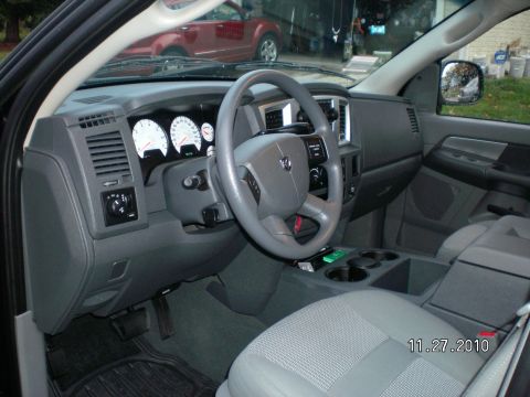 1996 Ford Bronco - The interior of a Dodge Ram pickup truck is shown, with a red vehicle visible through the windshield.