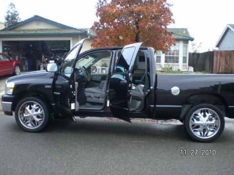 1996 Ford Bronco - Side view of a black 2007 Dodge Ram pickup truck with all doors open.