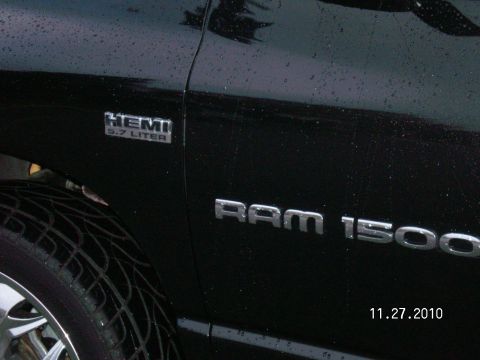 1996 Ford Bronco - Close-up of a black Dodge Ram 1500 pickup truck's side, the HEMI 5.7 LITER badge.
