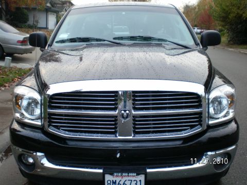 1996 Ford Bronco - Front view of a black Dodge Ram truck with a chrome grille, parked on a street.
