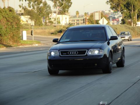 1995 Ford Taurus - A black Audi A6 sedan is seen driving on a highway, captured from the front perspective.