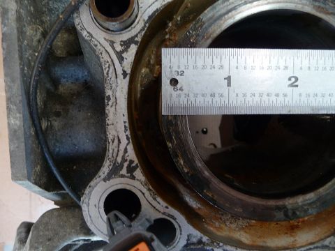 1993 Mazda MX-3 - A ruler is used to measure the diameter of an engine cylinder bore, indicating a mechanical part.