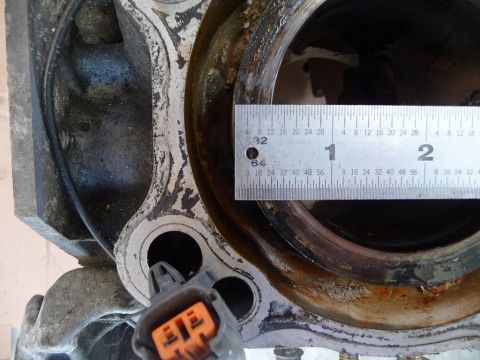 1993 Mazda MX-3 - A ruler measures the diameter of an engine cylinder bore, revealing signs of corrosion and damage.
