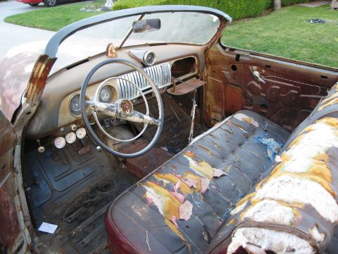 1986 Ford Bronco - The interior of this classic convertible shows significant rust and wear on the seats and dashboard.