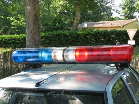 1991 Ford Crown Victoria - A police light bar with red and blue lights is mounted on the roof of a vehicle.