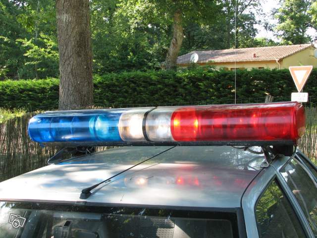 Police light bar with red and blue lights mounted on a car roof