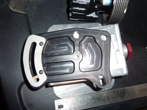 1971 Ford Mustang - A black gasket with stamped part numbers is shown with a power steering pump and a ruler for scale.