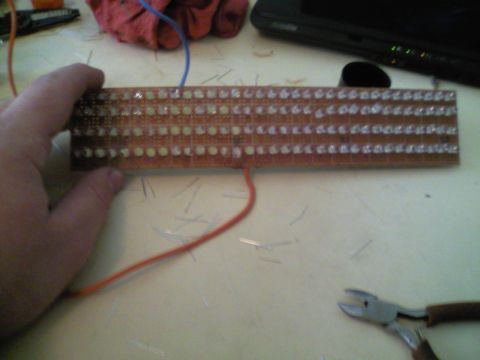 1989 Ford Bronco - A circuit board with many LEDs and wires is being held by a hand.
