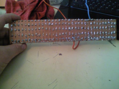 1989 Ford Bronco - A circuit board with numerous soldered components is held by a hand, with wires attached.