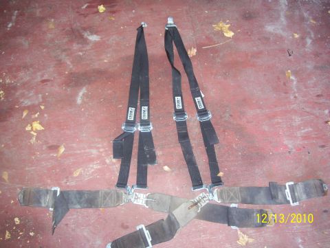 1978 Ford Bronco - Racing seat belts with "Crow" labels are shown on a red floor with debris.