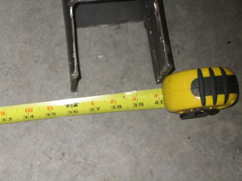 1984 Ford Bronco - A metal bracket is measured with a tape measure, showing a length of 39 inches.