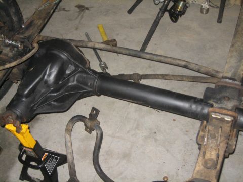 1984 Ford Bronco - Front axle assembly, likely from a 4x4 vehicle, is shown supported by a jack stand.