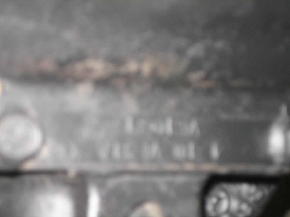 Close-up of a metal part with stamped numbers, including 'V461A 01 0'