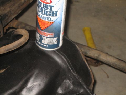 1984 Ford Bronco - A can of spray paint sits on a black metal component, with hoses and pipes visible in the background.