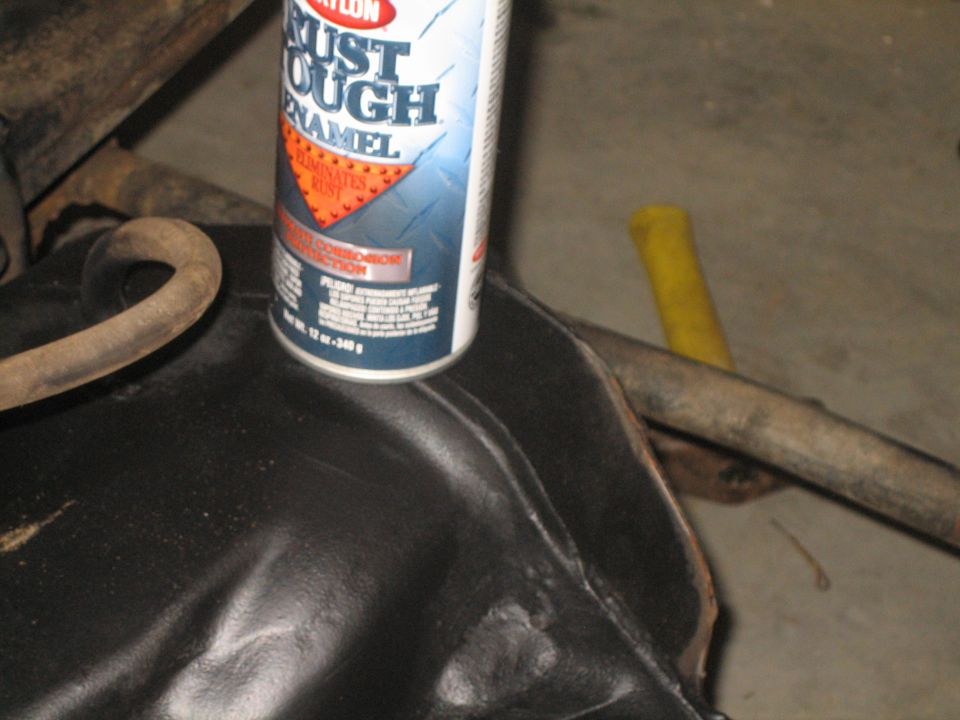 Spray paint can on black metal part with hoses and pipes