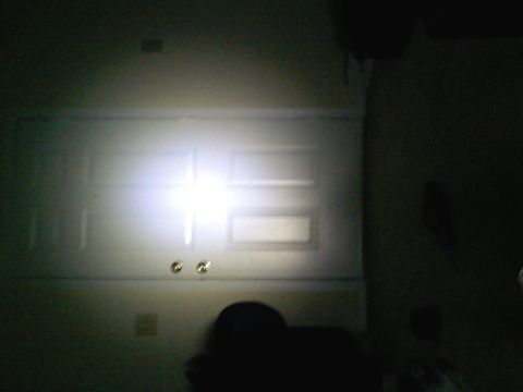 1990 Ford Bronco - Bright LED light bar illuminates a white door, obscuring details.