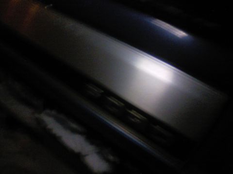 1989 Ford Bronco - Close-up of chrome trim with visible yellow lights, likely from a vehicle's interior or exterior.