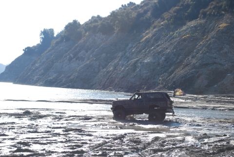 1996 Ford Bronco - Ford Bronco navigating a challenging muddy terrain near a body of water.