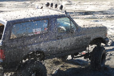 1996 Ford Bronco - This SUV is covered in mud, suggesting it has been off-roading in a wet, muddy environment.
