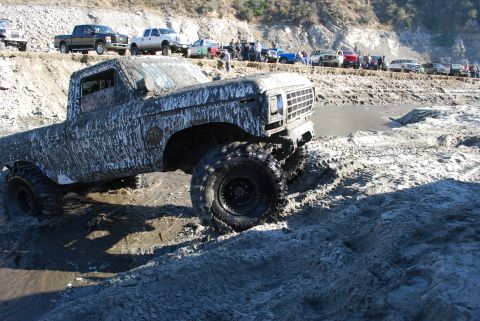 1996 Ford Bronco - Muddy 1979 Ford F-Series pickup truck navigating a difficult off-road terrain.