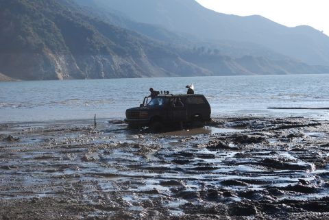 1996 Ford Bronco - Off-roading adventure: 1996 Ford Bronco gets stuck in the mud near a large body of water.