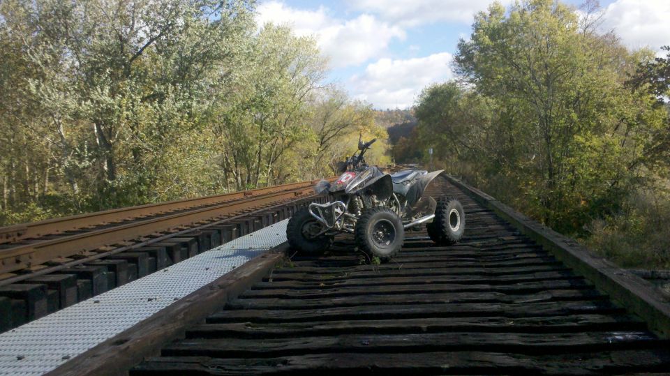 Black ATV on railroad tracks, front view