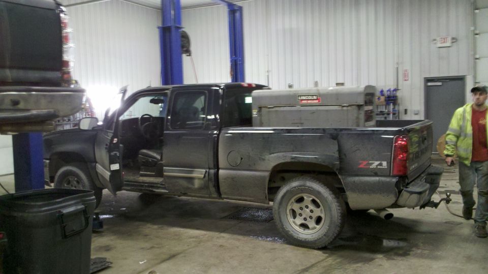 Side view of a black 2003 Chevrolet Silverado 1500 pickup truck with doors open