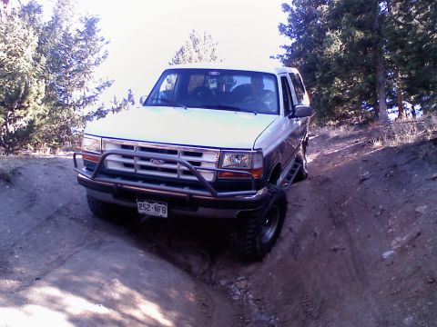 1996 Ford Bronco - 1996 Ford Bronco navigates a challenging off-road trail, demonstrating its capability.