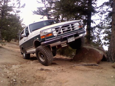 1996 Ford Bronco - This two-tone green and white Ford Bronco is navigating a rocky off-road course.