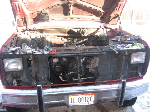 1981 Ford Bronco - The engine bay of a red Ford truck is shown with the hood up and various tools laid out.