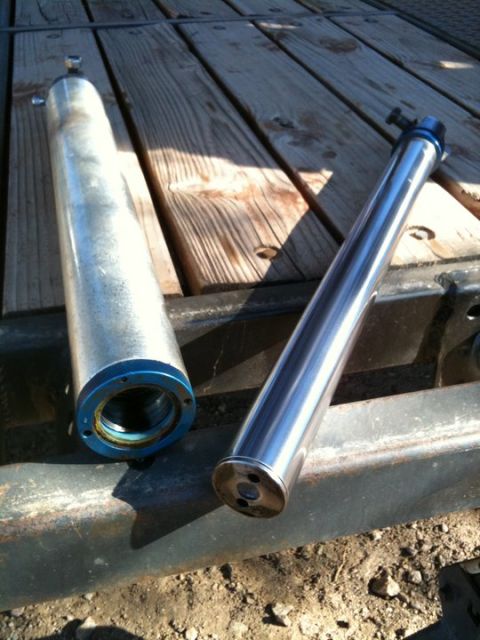 1966 Ford Bronco - Two shock absorbers are displayed on a wooden surface, with a watermark for Supermotors.net visible.