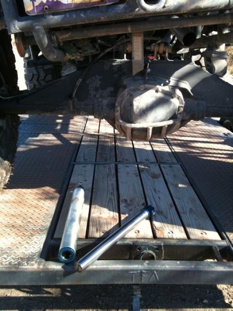1966 Ford Bronco - Rear axle assembly and two shock absorbers are on a trailer deck, possibly for repair or transport.