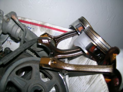 1995 Ford Probe - Close-up view of engine pistons and connecting rods, with a pulley in the foreground.
