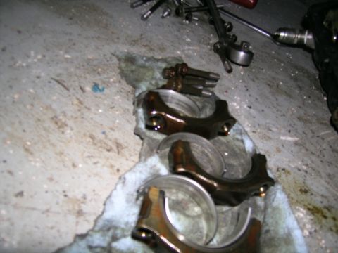 1995 Ford Probe - Engine parts, including connecting rods and bearings, are shown on a rag with tools in the background.
