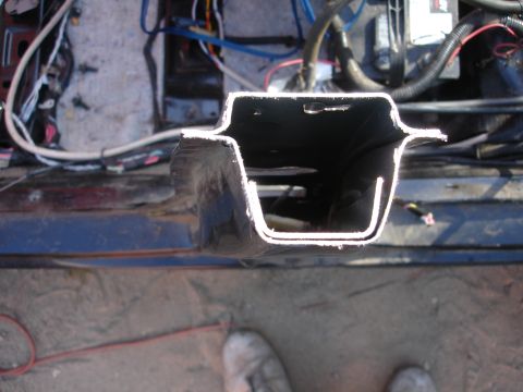 1989 Ford Taurus - Close-up view of a cut metal structural component with visible wiring and engine parts in the background.