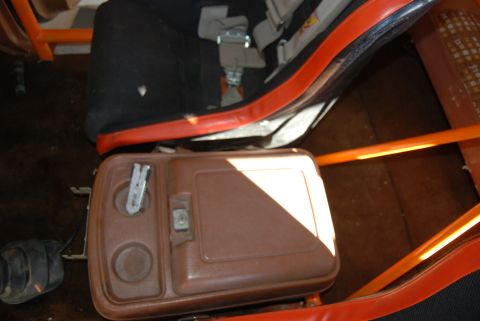 1982 Ford Bronco - Interior view of a vehicle's center console and racing seat, with an orange roll cage visible.