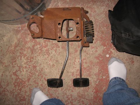 1994 Ford Bronco - Rusty brake and clutch pedal assembly shown on a concrete floor.