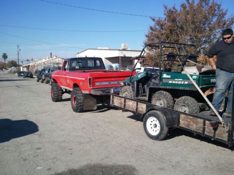 1979 Ford Bronco - Red pickup truck towing a trailer with a UTV. The truck appears to be from the late 1970s.