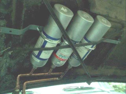 1978 Ford Bronco - Close-up view of multiple onboard air tanks and copper piping installed in a vehicle.