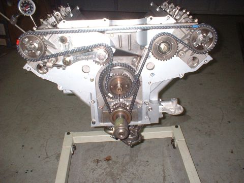 1965 Shelby Cobra - Engine assembly on a stand, showing the timing chain and gears with a dial indicator attached to measure valve timing.