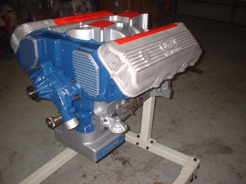 1965 Shelby Cobra - A Ford 427 SOHC engine, painted blue and silver with red accents, is mounted on a stand.